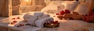 Folded towels and rose petals on a warm marble bench